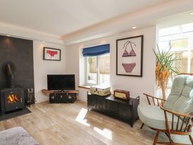 A living room with a television and artwork at Kiloran in Rhosneigr