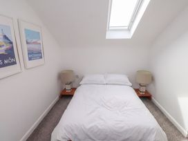 A bedroom with a bed and side tables at Kiloran in Rhosneigr