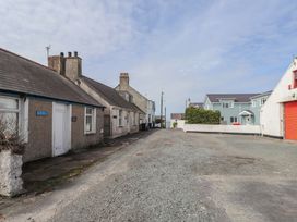 A street with houses and cloudy sky at Kiloran in Rhosneigr