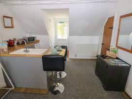 A kitchen with a sink and bar stools at Seaside Steps in Goodwick