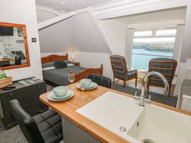 A studio room with a bed, dining area and view at Seaside Steps in Goodwick