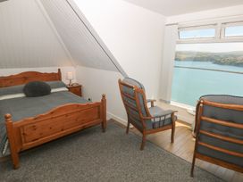 A bedroom with a bed and chairs at Seaside Steps Goodwick