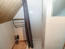 A bathroom with a shower curtain and towel rack at Seaside Steps in Goodwick