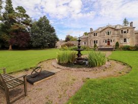 A garden with a fountain and a house in the background at Rochester Apartment in Orton