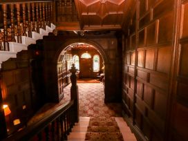 A hallway with a staircase and wooden paneling at Rochester Apartment in Orton