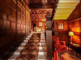 A hallway with a staircase and seating area at Rochester Apartment in Orton