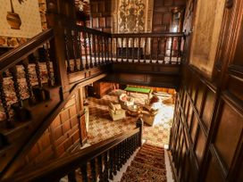 A staircase leading down to an entrance hall with a sofa and coffee table at Rochester Apartment in Orton