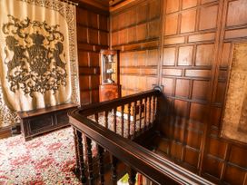 A hallway with wall paneling and a tapestry at Rochester Apartment in Orton