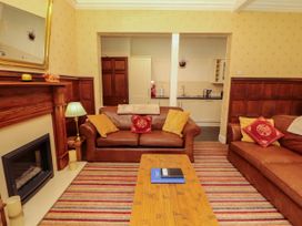 A living room with a sofa, coffee table, and fireplace at Rochester Apartment in Orton