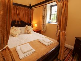 A bedroom with a four-poster bed and window at Rochester Apartment in Orton