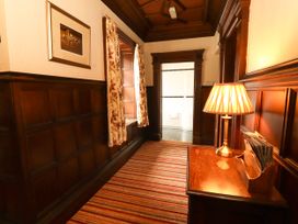 A hallway with a lamp and wooden furniture at Rochester Apartment in Orton
