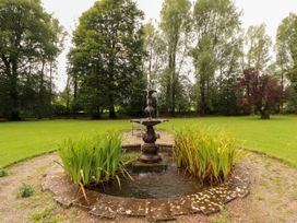 A fountain surrounded by plants in a garden at Rochester Apartment in Orton