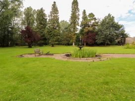 A garden with a pond and bench at Rochester Apartment in Orton