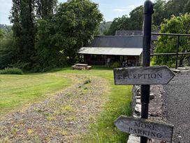 An outdoor area with signposts directing to reception and parking at Walnut Tree Lodge WITH hot tub Presteigne