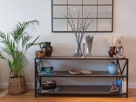 A shelf with plants and decorative items at Anchors Rest in St. Ives