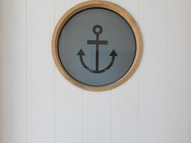 A round wall decoration featuring an anchor design at Anchors Rest in St. Ives