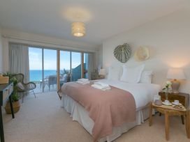 A bedroom with a bed and balcony view at Anchors Rest in St. Ives