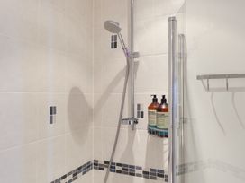 A shower with tiles and toiletries at Anchors Rest in St. Ives