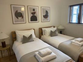 A bedroom with twin beds and wall art at Anchors Rest in St. Ives