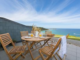 An outdoor seating area with a table and chairs at Anchors Rest in St. Ives