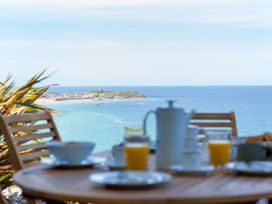 An outdoor dining area with a view of the sea at Anchors Rest in St. Ives