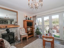 A living room with a fireplace and a television at 7 The Cedars Wotton-Under-Edge