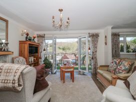 A living room with a sofa, chair, and coffee table at 7 The Cedars in Wotton-Under-Edge