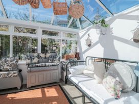 A conservatory with a sofa and a daybed at 7 The Cedars in Wotton-Under-Edge