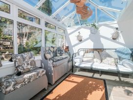 A conservatory with seating and a rug at 7 The Cedars in Wotton-Under-Edge