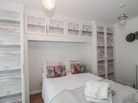 A bedroom with a bed and wardrobe at 7 The Cedars in Wotton-Under-Edge