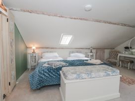 A bedroom with a bed and table at 7 The Cedars in Wotton-Under-Edge