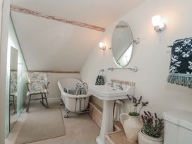 A bathroom with a bathtub and sink at 7 The Cedars Wotton-Under-Edge
