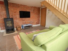 A living room with a sofa and stove at Millmead House Annex in Portesham