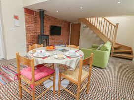 A living room with a dining table and green couch at Millmead House Annex Portesham