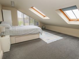 A bedroom with a bed and windows at Millmead House Annex Portesham