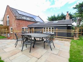 A patio area with a table and chairs at Bramley Cottage in Worlingham