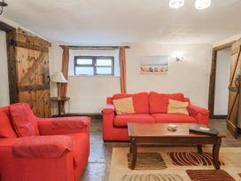 A living room with two red sofas and a coffee table at Cider House in Hawkchurch