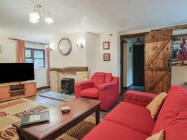 A living room with a fireplace and sofa at Cider House in Hawkchurch