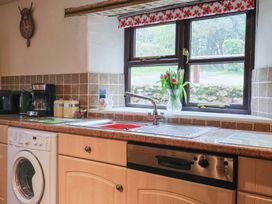 A kitchen with a washing machine and coffee maker at Cider House, Hawkchurch