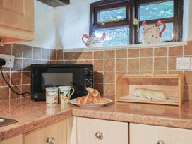 A kitchen with a microwave and baked goods at Cider House in Hawkchurch