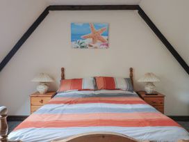 A bedroom with a bed and lamps on nightstands at Cider House in Hawkchurch