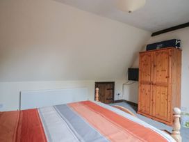 A bedroom with a bed and a wardrobe at Cider House in Hawkchurch