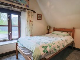 A bedroom with a bed and window at Cider House in Hawkchurch