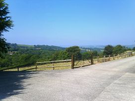 An outdoor area with a gate and road leading to hills at Cider House in Hawkchurch