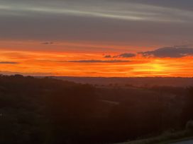 A sunset view over hills and trees at Cider House in Hawkchurch