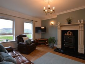 A living room with a television and fireplace at An Grianan Getaway in Burt