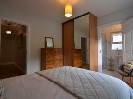 A bedroom with a bed and dresser with mirror at An Grianan Getaway Burt