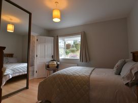 A bedroom with a bed and mirror at An Grianan Getaway in Burt