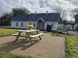 A house with a picnic table and flowers at An Grianan Getaway in Burt