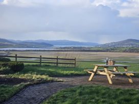 An outdoor area with a picnic table overlooking a field at An Grianan Getaway in Burt